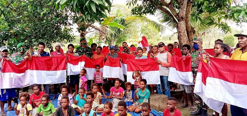 Jelang HUT Kemerdekaan RI ke-75, Satgas Yonif 125 Bagikan Bendera Merah Putih Kepada Warga Kampung Sota dan Toray